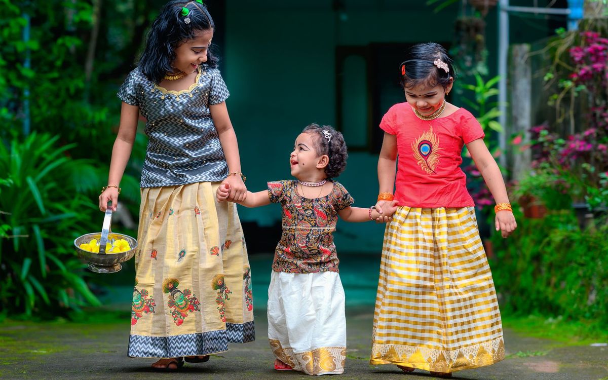 Three young sisters walking hand in hand outside their home